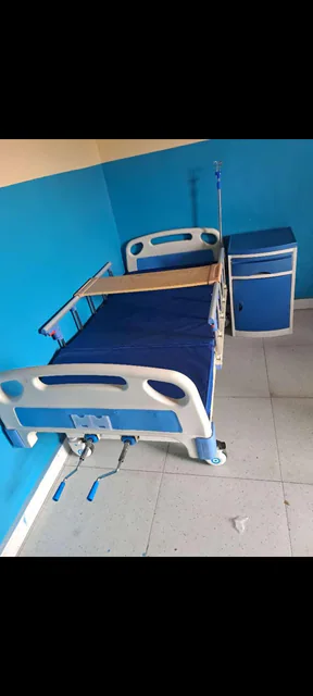 Lit médicalisé avec table de chevet et support perfusion